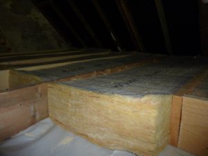 Plaatsing van glaswol op de zoldervloer afgewerkt met bruggen en OSB – platen
